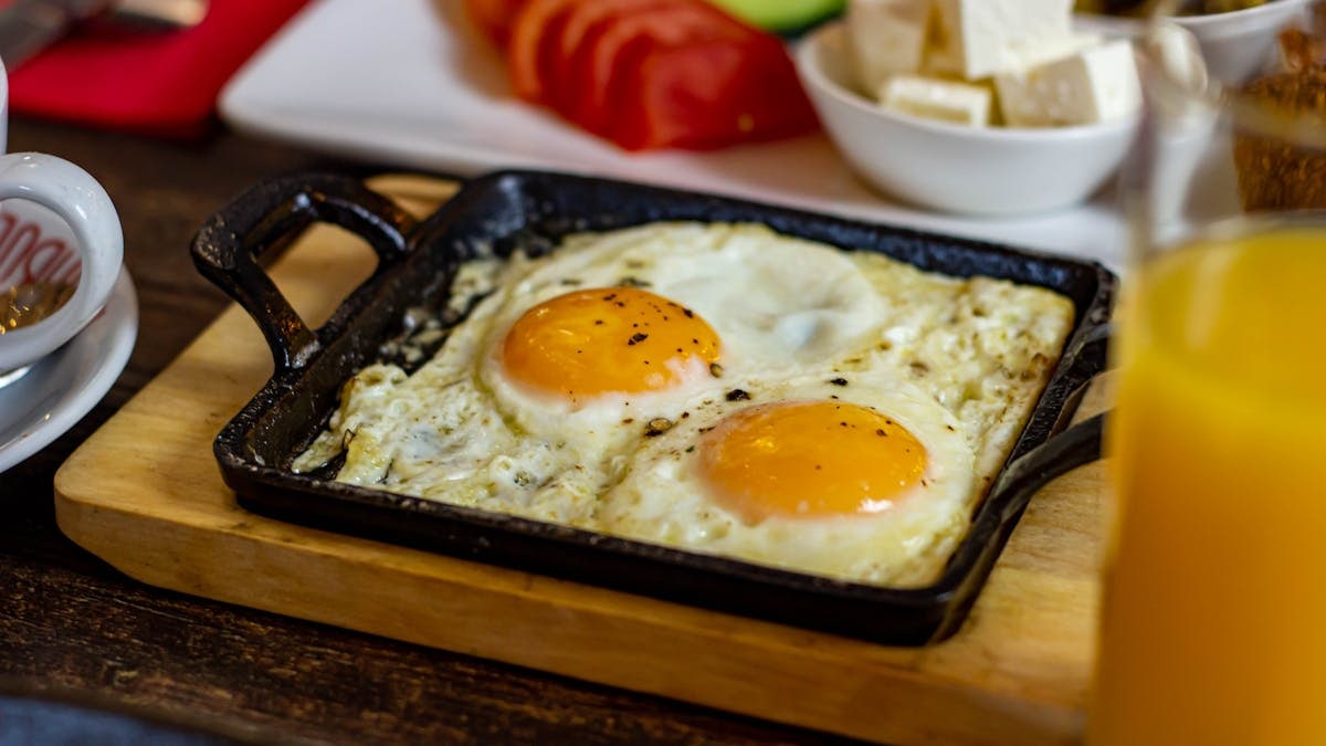 A scrumptious breakfast featuring sunny side up eggs and fresh sides in Cheadle, England.